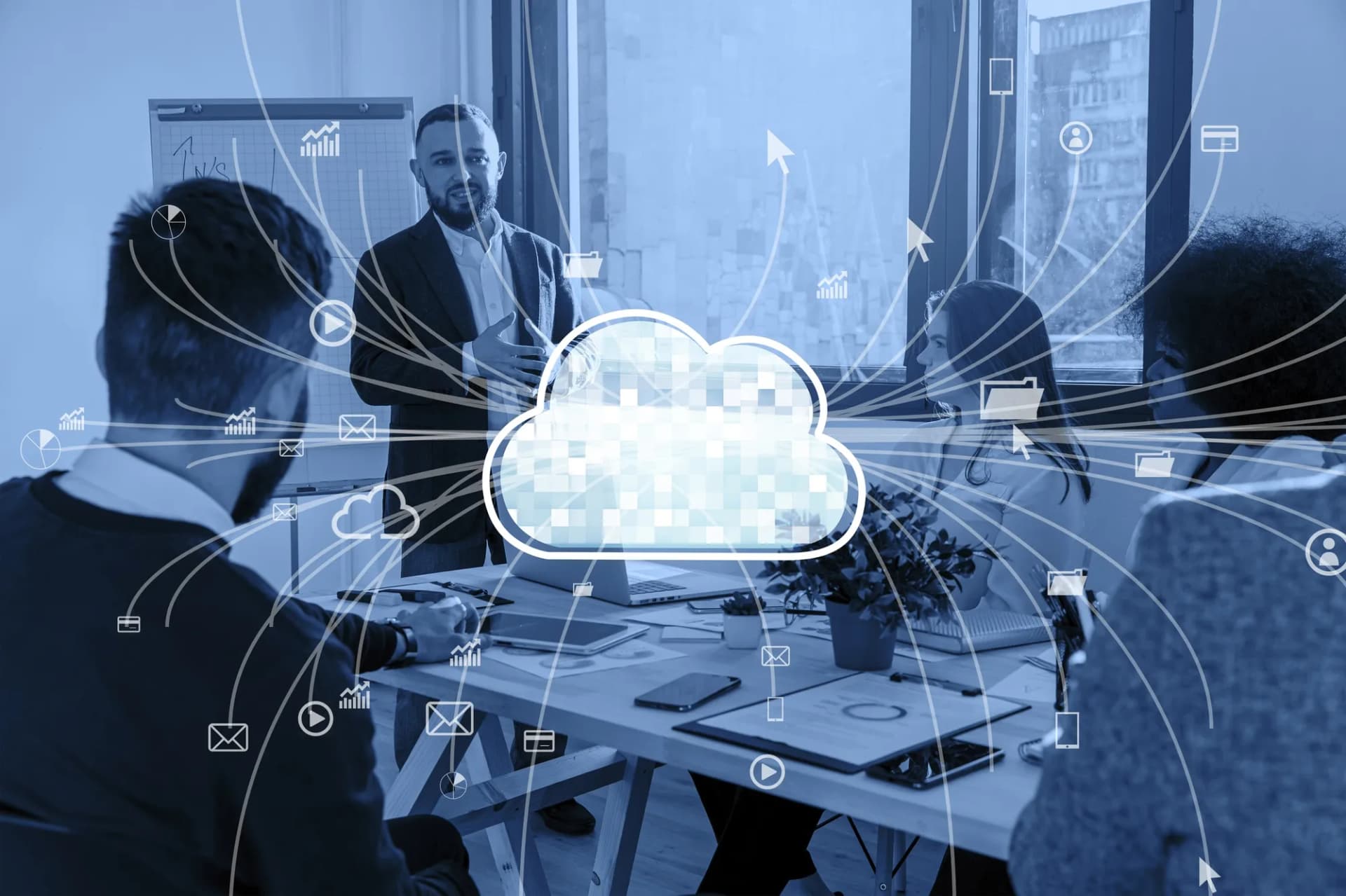 Blue-tinted photo of a man presenting to colleagues around a meeting table, overlaid with a central cloud icon and lines linking data icons